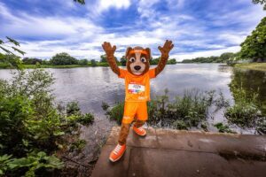 B2Run Bremen 2026 Maskottchen Buddy händeerhoben am Wasser
